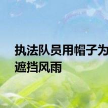 执法队员用帽子为孩子遮挡风雨