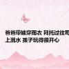 爸爸带娃穿雨衣 拜托过往司机往身上溅水 孩子玩得很开心
