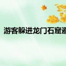 游客躲进龙门石窟避雨